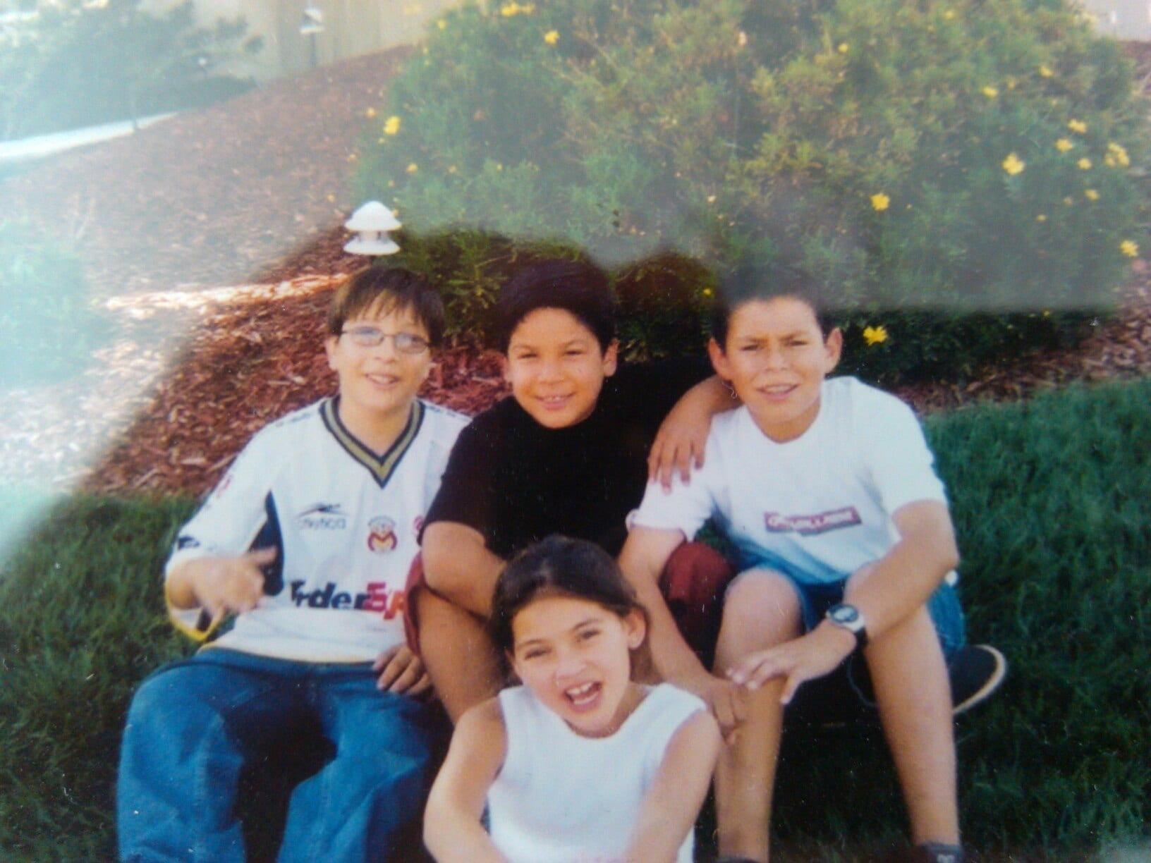 Jose Moreno, Javy Moreno, Anthony Moreno, and Samantha Moreno sitting on the grass